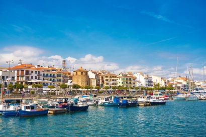 CAMBRILS, SPAIN – APRIL 30, 2017: View of port and city waterfront with Church Of Saint Peter in middle and Torre del Port. Copy space for text